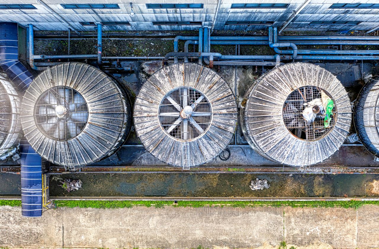 Overhead drone view of metal big ventilation system with grid and tubes in industrial area on factory at daytime